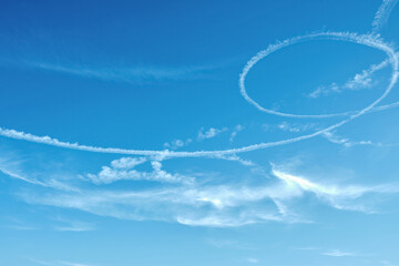 clear blue sky with unusual circular patterns , cloud trail from the plane