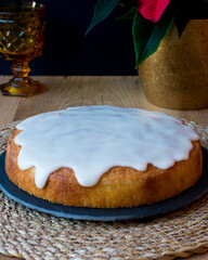 Sponge cake with icing on top on black slate plate