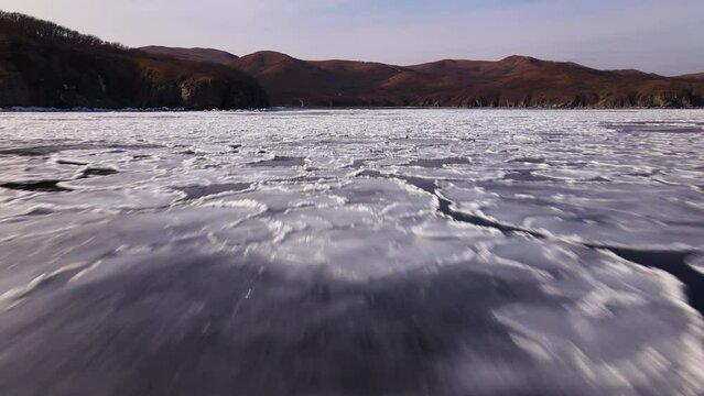 Close flight of a drone over the surface of a sea with ice floes