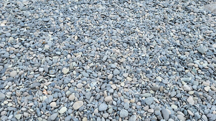 Background of grey sea pebbles on a summer day.