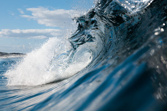 Crisp details of a breaking wave under sunlight