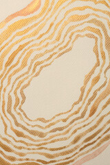Gold nacre glitter ink watercolor wave line stain blot on beige grain paper texture background.