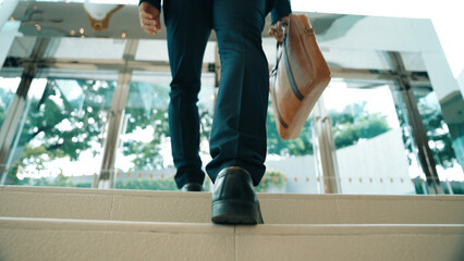 Closeup of business man leg go up the stairs. Successful man going up the stairs while explore a...