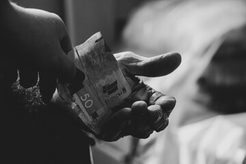 A woman's hand gives fifty hryvnia to her grandmother, asks and gives money, financial support for...