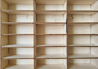 A light plywood empty shelf with many compartments.