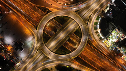 Aerial drone slow shutter night photo of illuminated urban elevated toll ring road junction and...