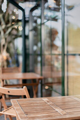 Wooden table and chair outside near window, cafe or restaurant. Photo of a table with space for copy, advertising and text
