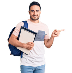 Young handsome man wearing student backpack and notebook smiling happy pointing with hand and finger to the side