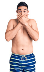 Fototapeta premium Young handsome man wearing swimwear shocked covering mouth with hands for mistake. secret concept.
