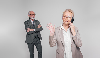 Senior businesswoman talking over smart phone and refusing to listen businessman on white background