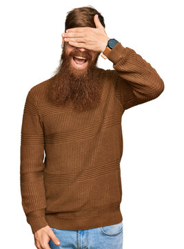 Young irish redhead man wearing casual clothes and glasses smiling and laughing with hand on face covering eyes for surprise. blind concept.