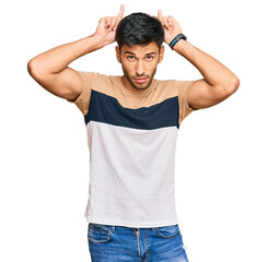 Fototapeta premium Young handsome man wearing casual clothes doing funny gesture with finger over head as bull horns