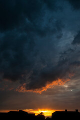 Abstract colorful background. Beautiful red sunset over a small town. Dramatic sunset sky with clouds.
