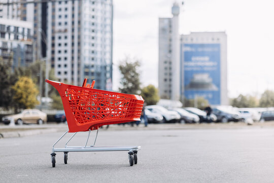 A red supermarket basket in the parking lot