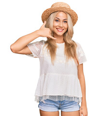 Young blonde girl wearing summer hat smiling doing phone gesture with hand and fingers like talking on the telephone. communicating concepts.