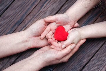 A Heart in hands on valentine's day on a wooden background holiday