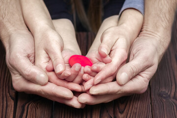 A Heart in hands on valentine's day on a wooden background holiday