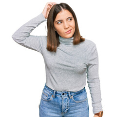 Young beautiful woman wearing casual turtleneck sweater confuse and wondering about question. uncertain with doubt, thinking with hand on head. pensive concept.