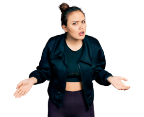 Young hispanic girl wearing sportswear clueless and confused with open arms, no idea concept.