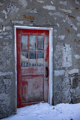 Porte rouge et mur de brique, jour, hiver,  vertical