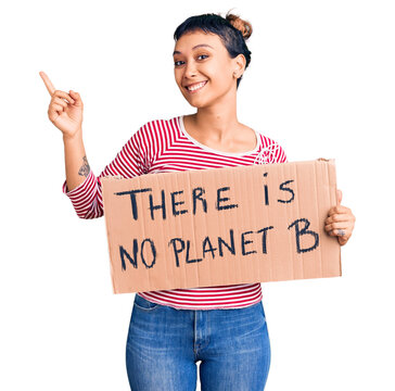Young woman holding there is no planet b banner smiling happy pointing with hand and finger to the side
