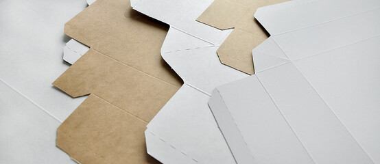 Artistic background of textured layers of unfolded cardboard boxes. Monochrome background, copy space. Sustainable packaging