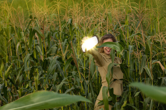 Magical light falls on the long hair blonde girl to the corn field in summer. Epressive girl in a corn field