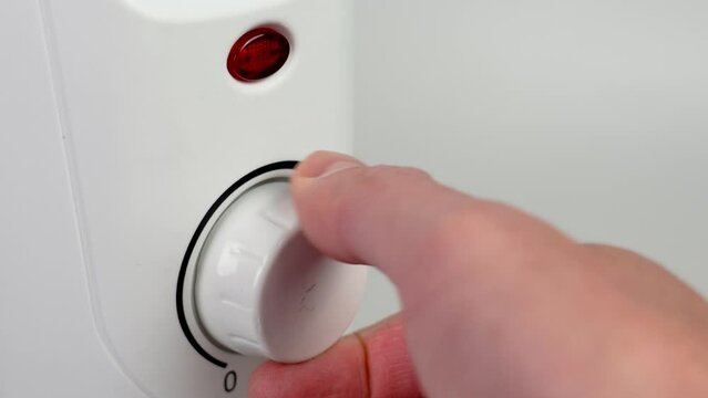 Setting the temperature of the electric convector radiator. The red heating signal lights up. Electricity consumption at home in winter concept