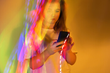 SMS short message service. Hands of woman holding cellphone and texting message on a neon glowing background