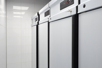 Refrigeration equipment for enterprises. Closed refrigeration chambers. Several refrigerators inside cafe. Freezers with temperature indicator. Refrigerators for catering establishments and cafe