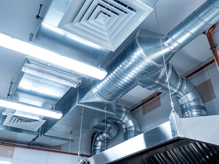 Restaurant ventilation system. Galvanized pipes with hoods. Ventilation ducts under ceiling. Air purification in confectionery shop. Ventilation of catering establishments. Restaurant equipment