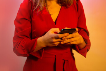 Closeup of female hands using modern smartphone with blank copy space. Womans hands holding mobile phone device on a neon glowing background