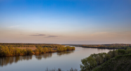Panoramic landscape of a wide river at sunset, evening landscape with a river to the horizon, early spring near the river