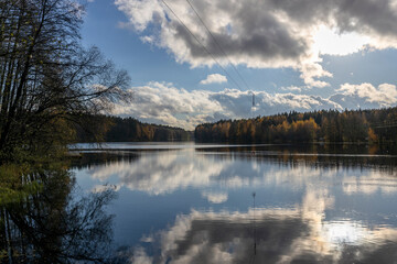 Wakeboarding rope against the backdrop of an autumn landscape, clouds reflected in the water