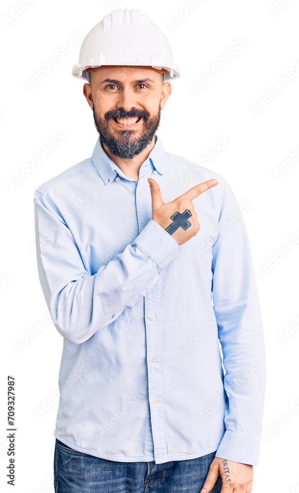 Poster young handsome man wearing architect hardhat cheerful with a smile of face pointing with hand and fi