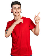 Young caucasian boy with ears dilation wearing casual red t shirt smiling and looking at the camera...