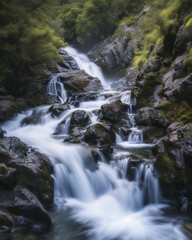 Naklejka na ściany i meble A long-exposure photograph capturing the power and motion of a waterfall in a natural setting, highlighting the beauty of flowing water