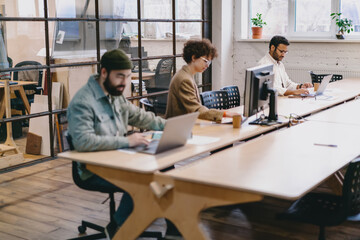 Diverse colleagues working on project at wooden table in office