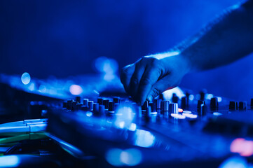 Dj hand using mixing console on live performance on a festival.