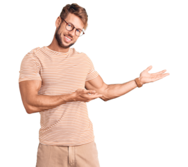 Young caucasian man wearing casual clothes and glasses inviting to enter smiling natural with open hand