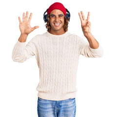 Obraz na płótnie Canvas Young hispanic man listening to music using headphones showing and pointing up with fingers number eight while smiling confident and happy.