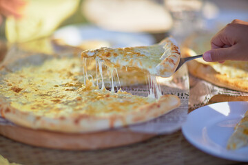 pizza in a summer cafe, stretched delicious cheese