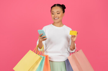 Smiling Asian Lady Holding Smartphone, Credit Card And Shopping Bags