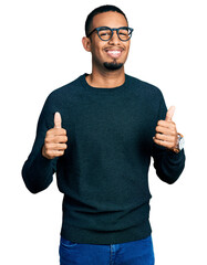Young african american man wearing casual clothes and glasses success sign doing positive gesture...