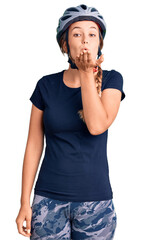 Beautiful caucasian woman wearing bike helmet looking at the camera blowing a kiss with hand on air being lovely and sexy. love expression.
