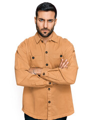 Young hispanic man wearing casual clothes skeptic and nervous, disapproving expression on face with crossed arms. negative person.