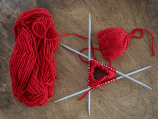 Yarn's Journey into Forming a Delightful Small Red Knitted Hat