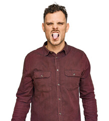 Obraz premium Young hispanic man wearing casual clothes sticking tongue out happy with funny expression. emotion concept.