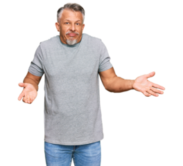 Middle age grey-haired man wearing casual clothes clueless and confused expression with arms and hands raised. doubt concept.