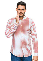 Fototapeta premium Young hispanic man wearing business shirt touching mouth with hand with painful expression because of toothache or dental illness on teeth. dentist